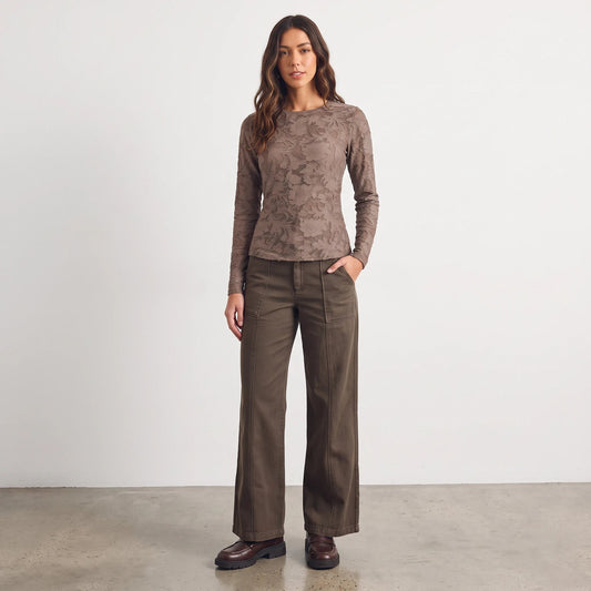 Model wearing Apricot Lane Duluth Roselyn floral long sleeve top in taupe with brown wide-leg trousers and loafers