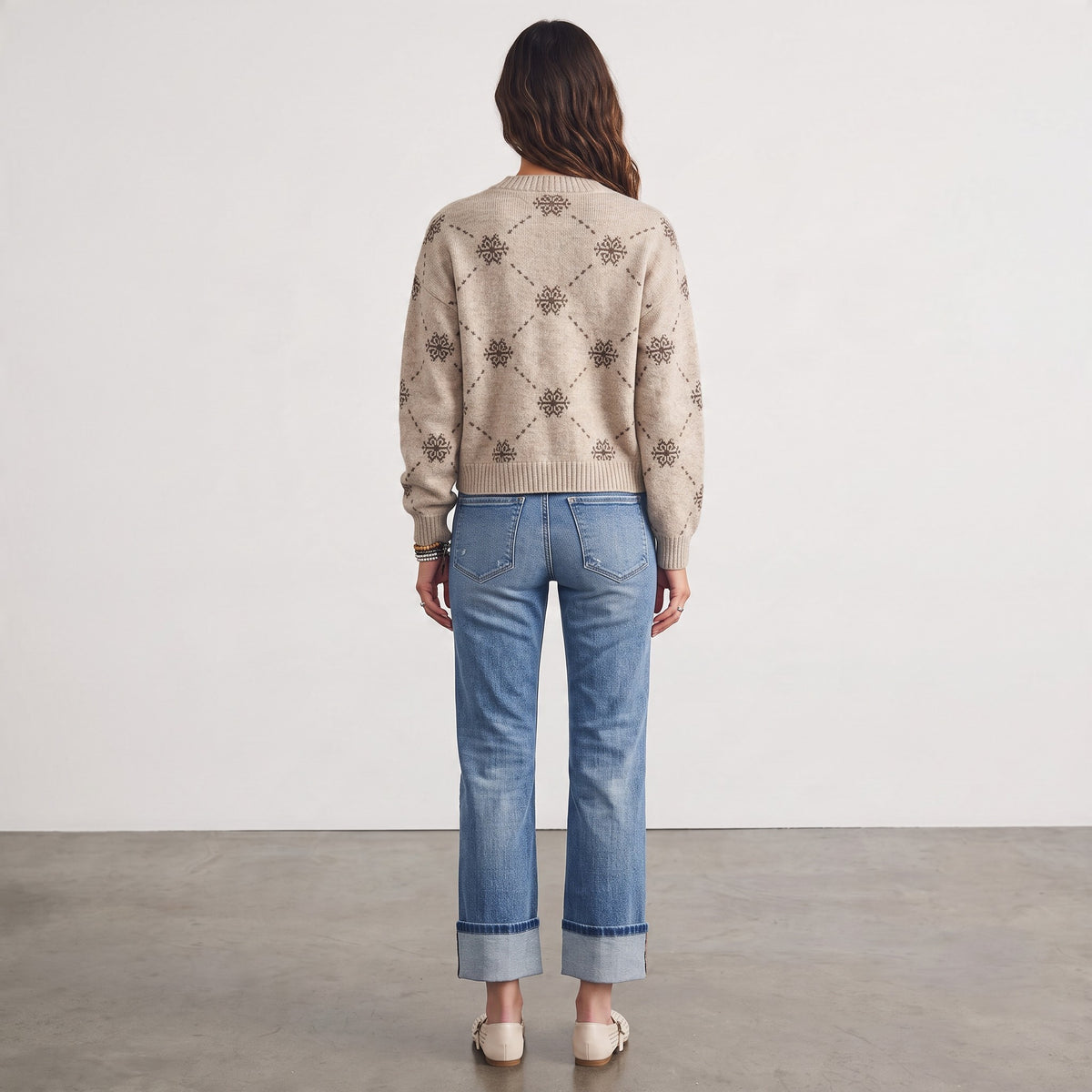 Back view of a woman wearing an Apricot Lane Duluth beige wool-blend cardigan with a snowflake and diamond pattern.