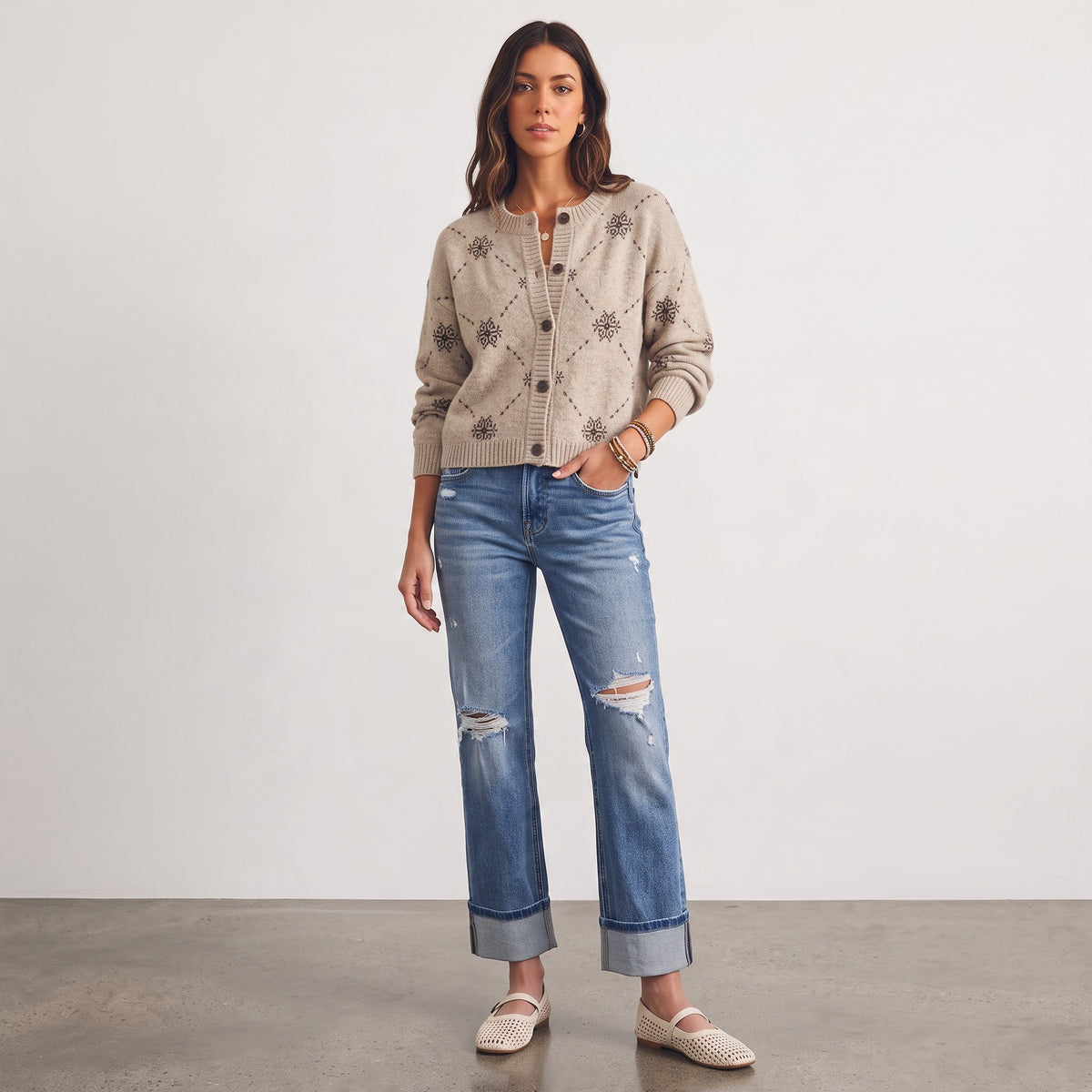 Model wearing an Apricot Lane Duluth beige wool-blend cardigan with snowflake jacquard pattern, jeans, and flats.