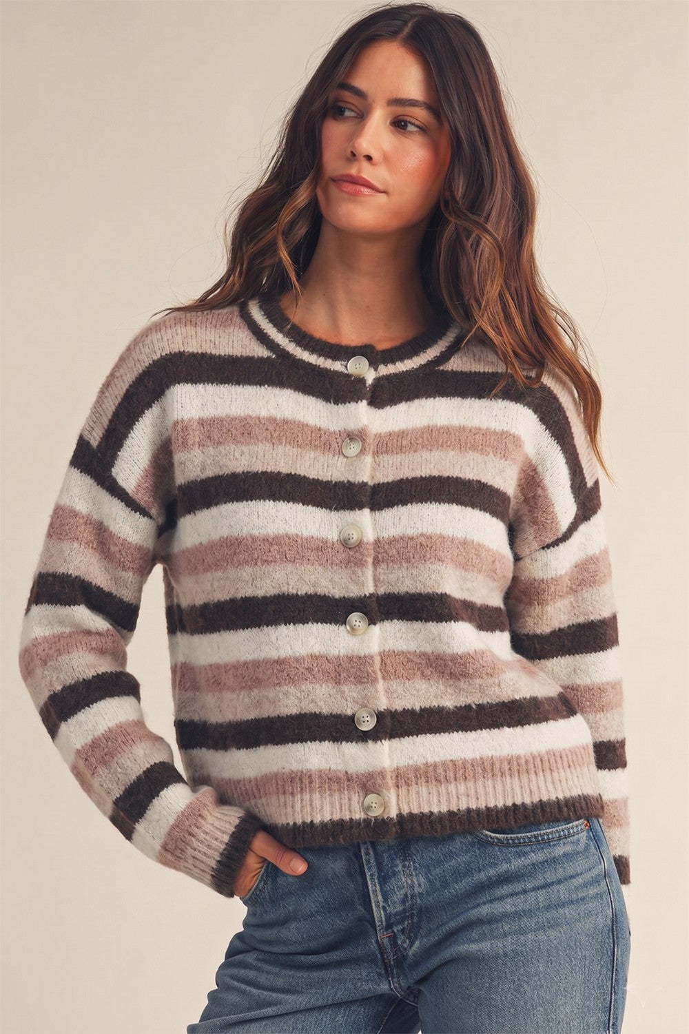 Model wearing Apricot Lane Duluth soft striped button-front cardigan in brown, pink, and white knit fabric.