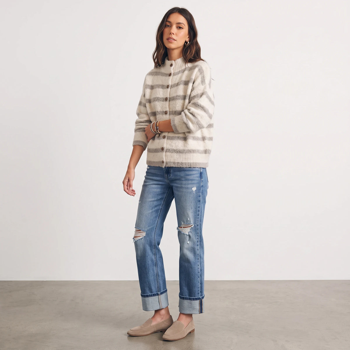 Model wearing Apricot Lane Duluth fuzzy knit striped cardigan with mock neck, button front, and distressed blue jeans.