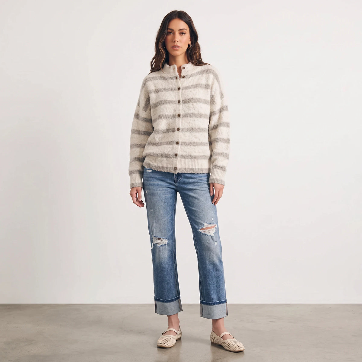 Model wearing Apricot Lane Duluth fuzzy knit striped cardigan with mock neck and button front, paired with blue jeans.