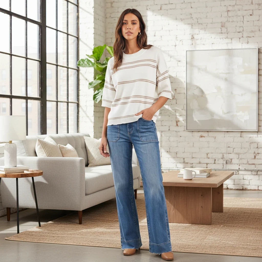 Apricot Lane Duluth model wearing a white and tan striped short-sleeve knit sweater with wide-leg blue denim jeans.