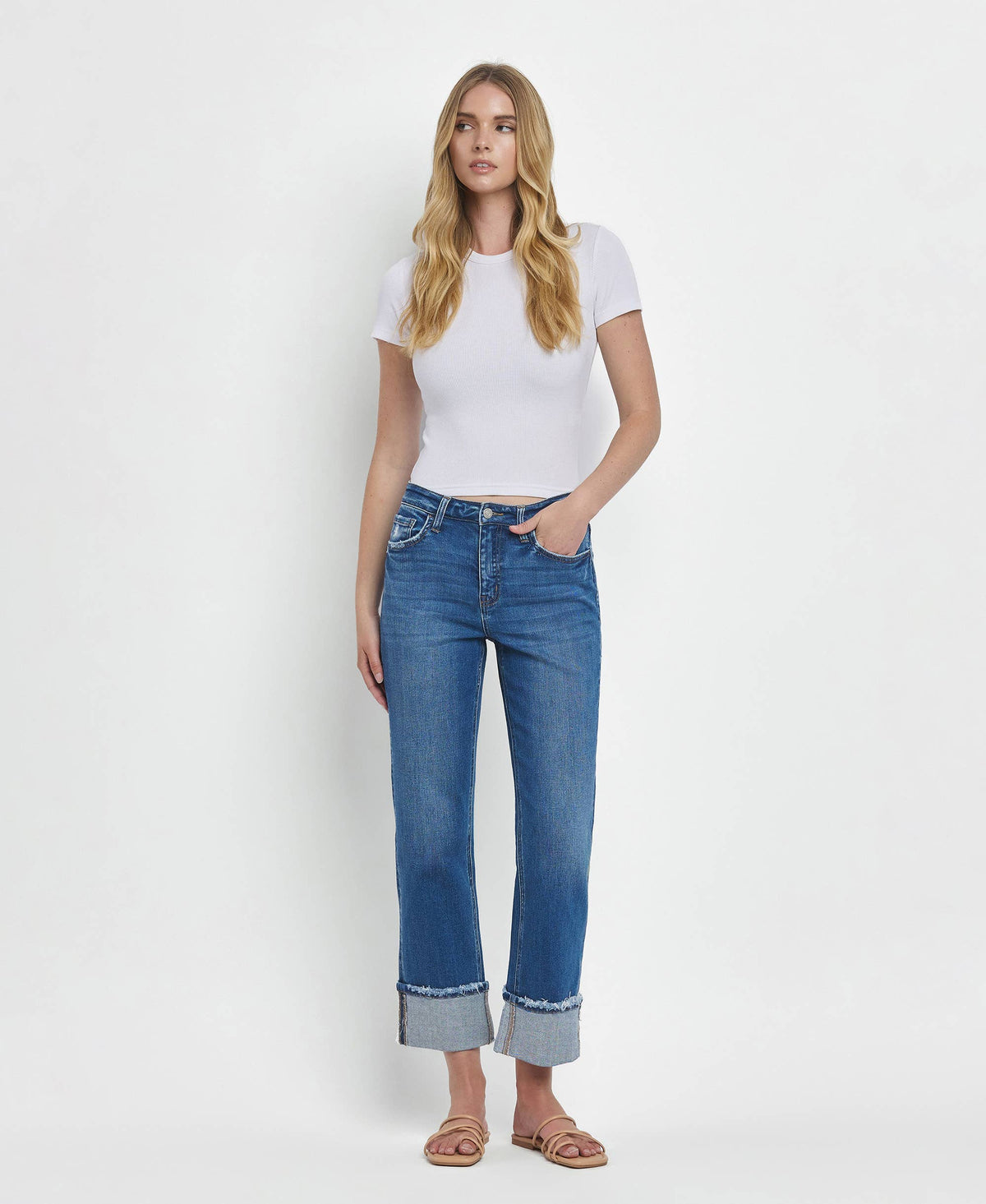Woman wearing a white t-shirt and blue jeans on a white background