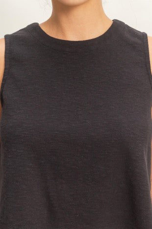 Black sleeveless top worn by a person on a plain background
