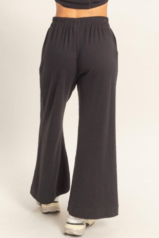 Black wide-leg pants worn by a person on a white background