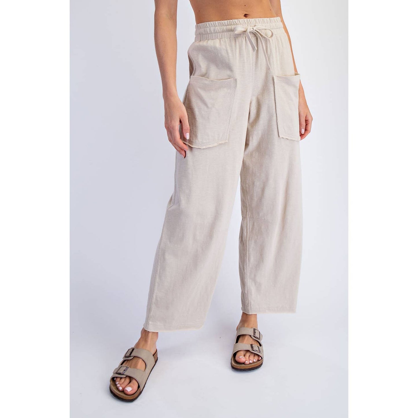 Beige wide-leg pants worn by a person on a white background