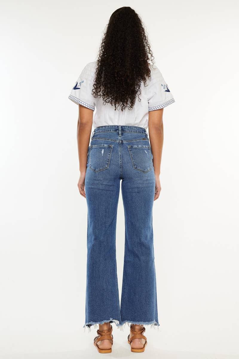 Person wearing a white top and blue jeans on a white background