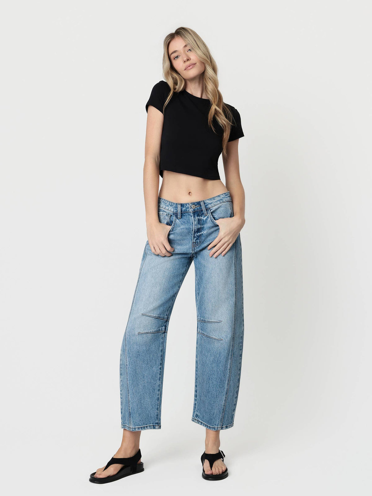Woman wearing a black t-shirt and blue jeans on a white background