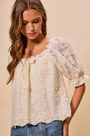 Woman wearing a lace blouse with a plain background