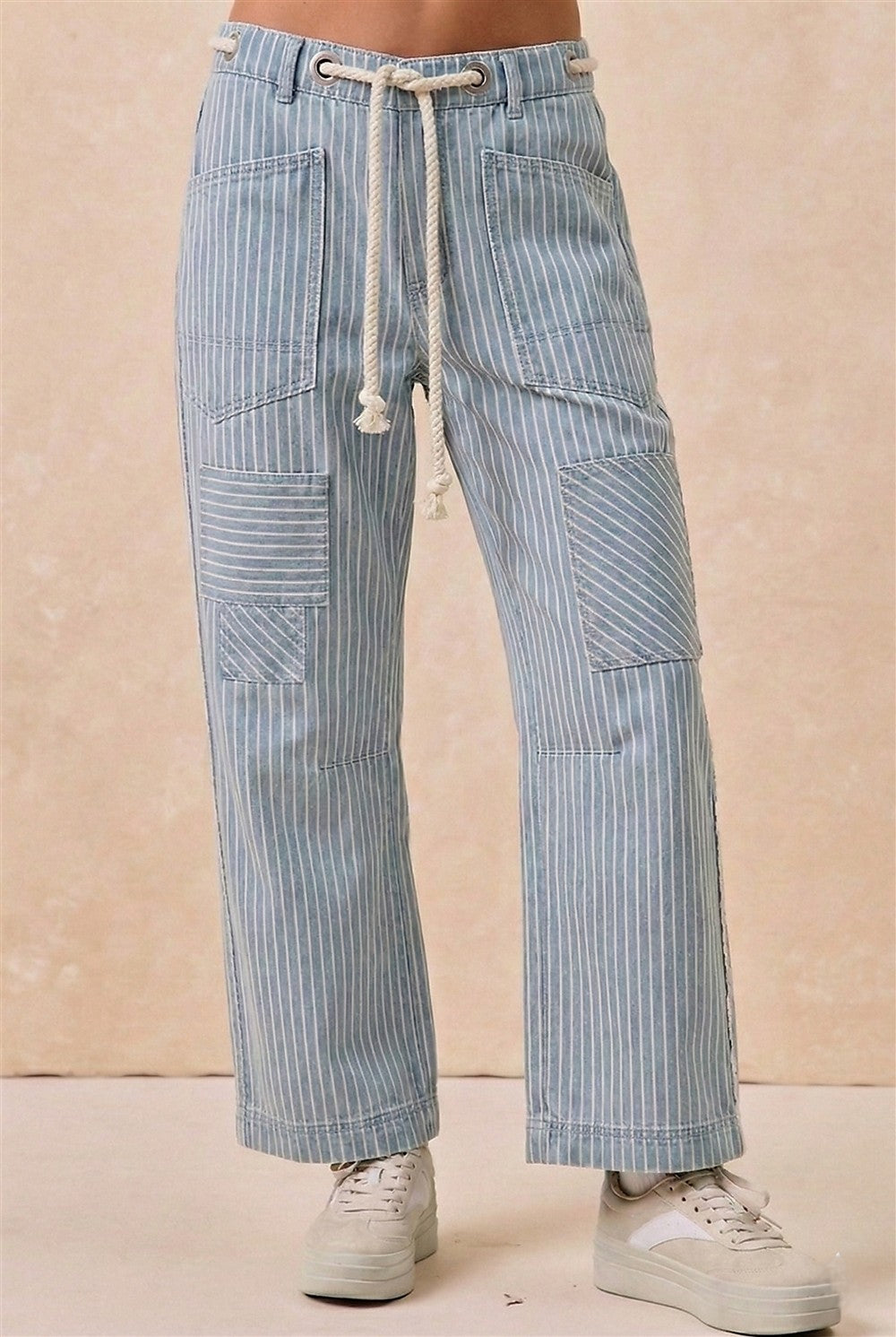 Blue striped pants worn by a person on a beige background