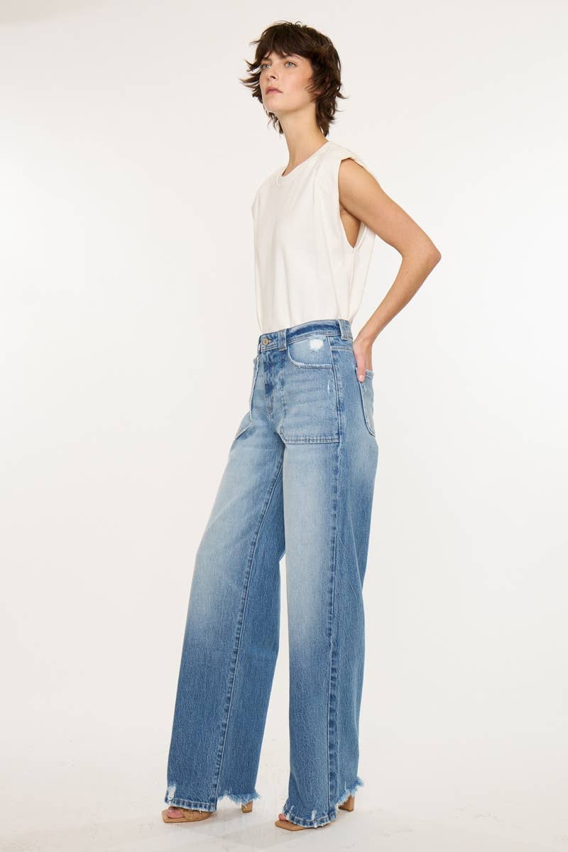 Woman wearing light blue jeans and a white top on a white background