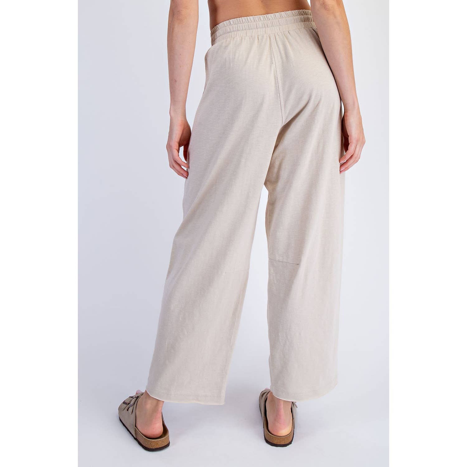 Beige wide-leg pants worn by a person on a white background