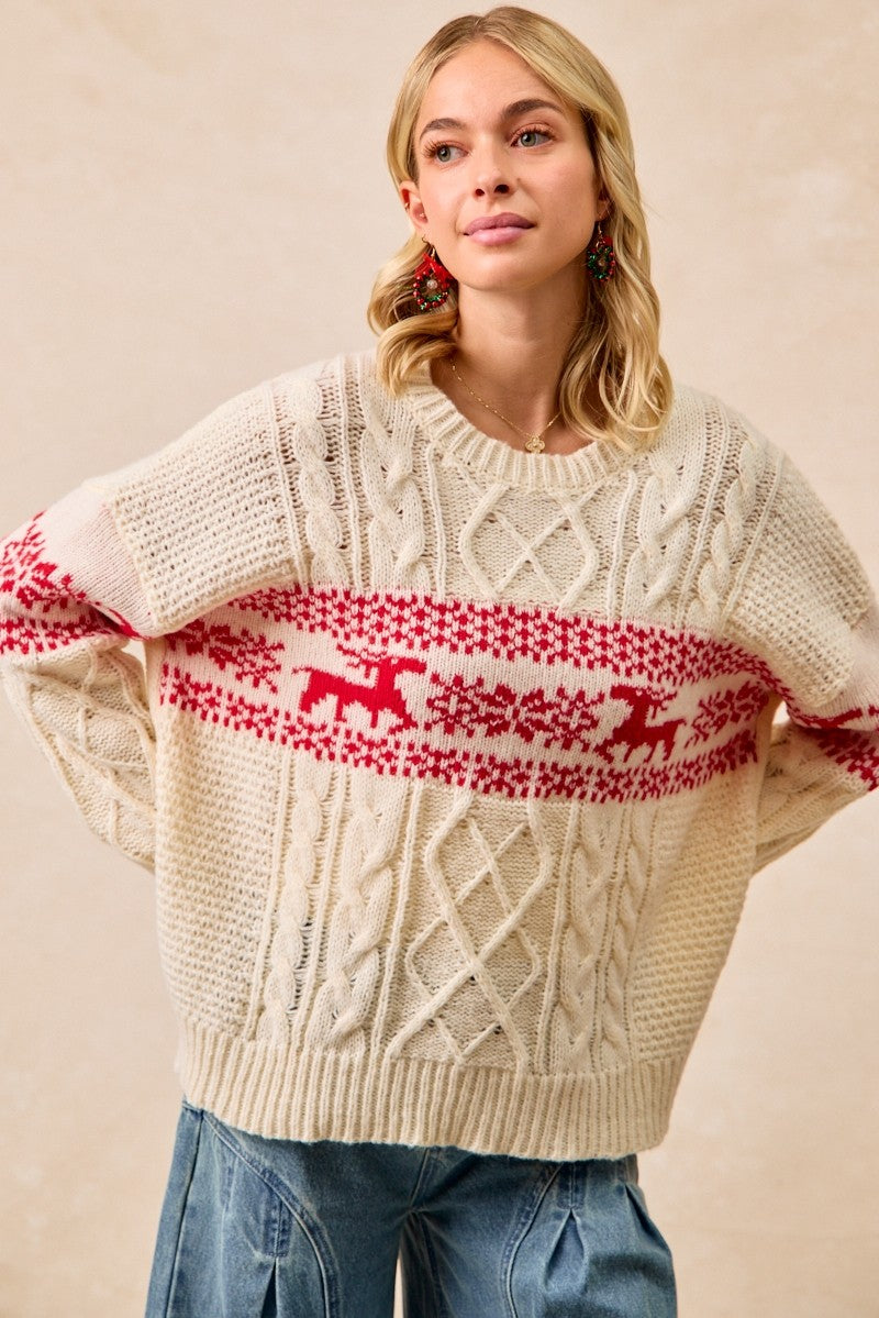 Woman wearing a cream sweater with red reindeer pattern on a beige background