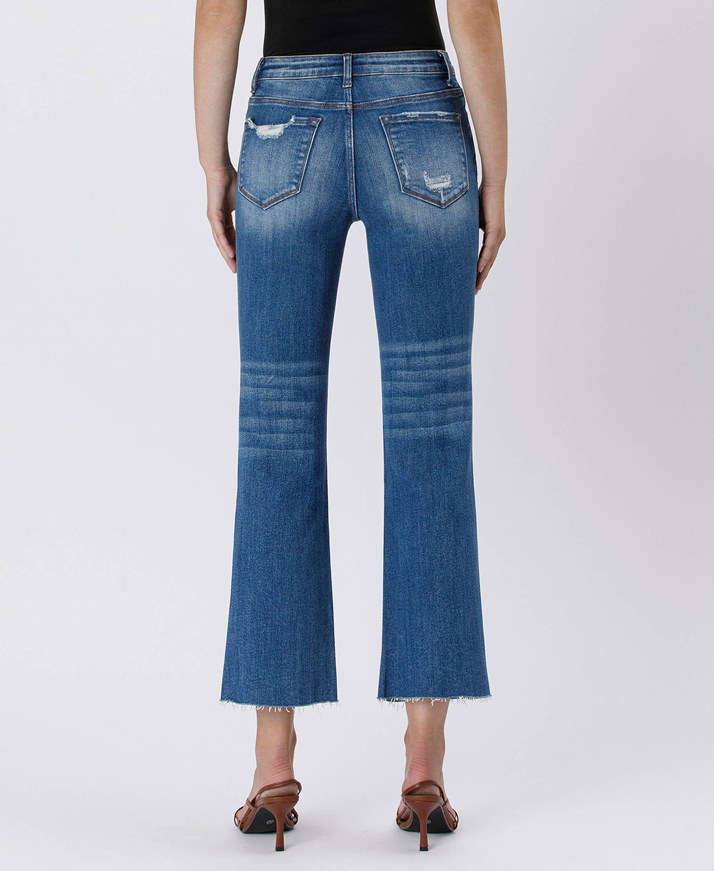 Blue jeans worn by a person on a white background