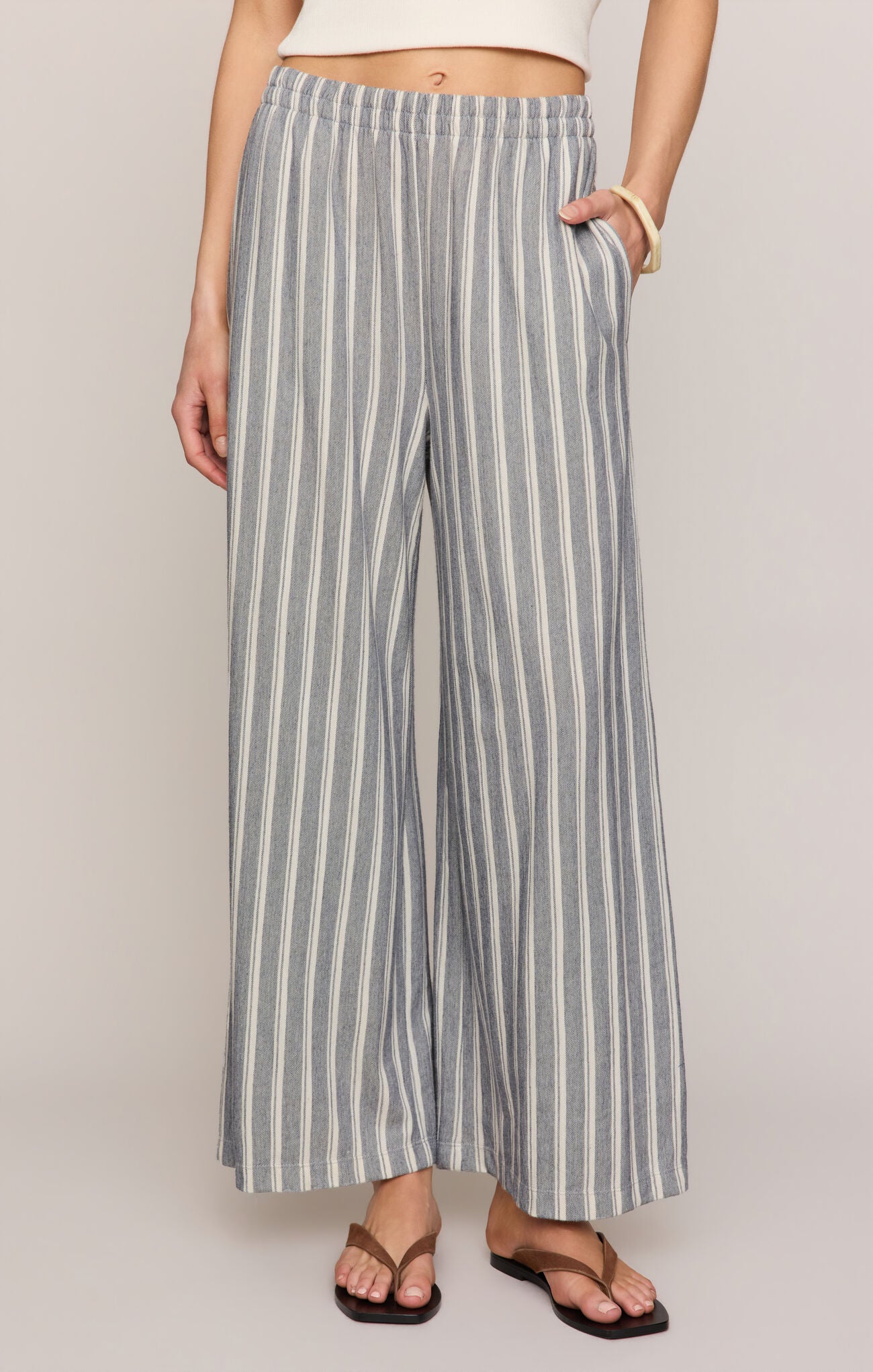 Person wearing blue and white striped pants with a plain background