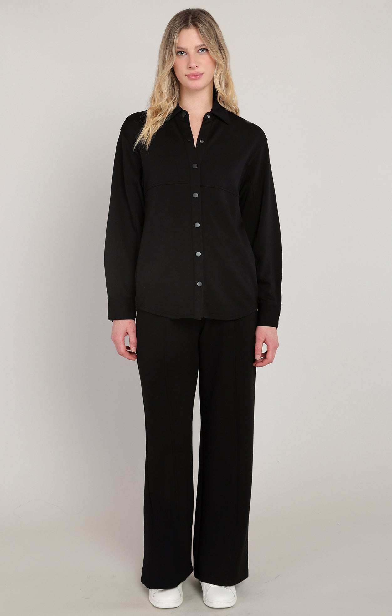 Woman wearing a black outfit with a plain background