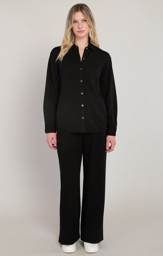 Woman wearing a black outfit with a plain background