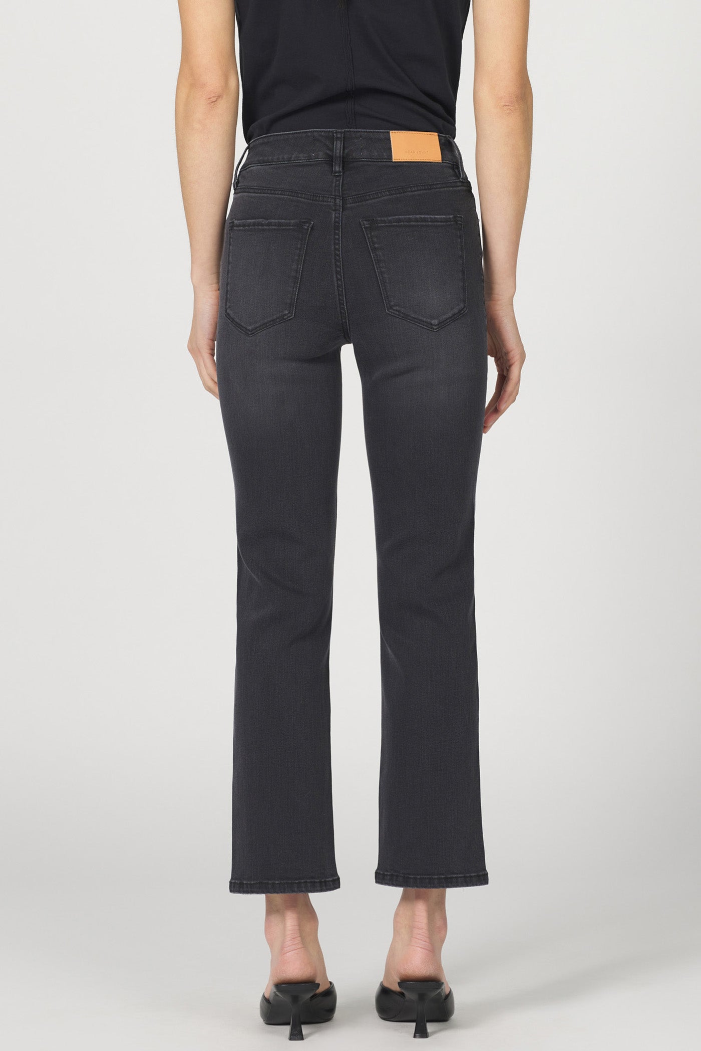 Person wearing black jeans on a white background